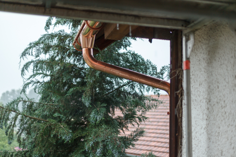 Image of D&B Guttering installing copper gutter and downspout